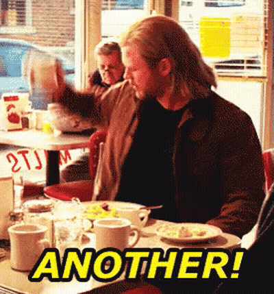 A Man Is Sitting At A Diner Table With Another Written On The Table GIF