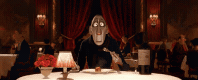 A Man Is Sitting At A Table In A Restaurant Eating A Piece Of Cake . GIF