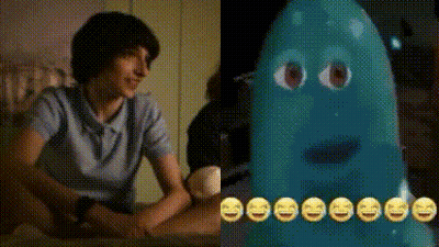 A Man Is Sitting At A Table Next To A Blue Ghost With Smiley Faces On Its Face . GIF