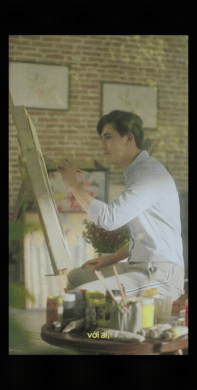 A Man Is Sitting At A Table Painting On An Easel And The Words Voi Ai Are On The Bottom GIF