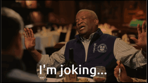 A Man Is Sitting At A Table With A Bottle Of Wine And Says I 'M Joking GIF