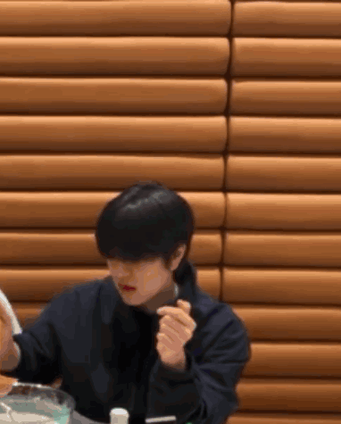 A Man Is Sitting At A Table With A Bowl Of Food In Front Of Him . GIF
