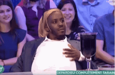 A Man Is Sitting At A Table With A Glass Of Wine . GIF