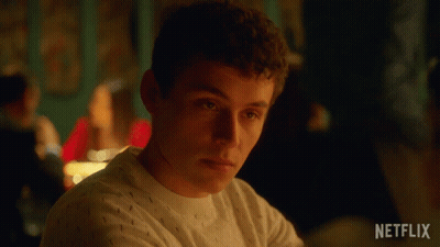 A Man Is Sitting At A Table With A Netflix Logo On The Bottom Right GIF