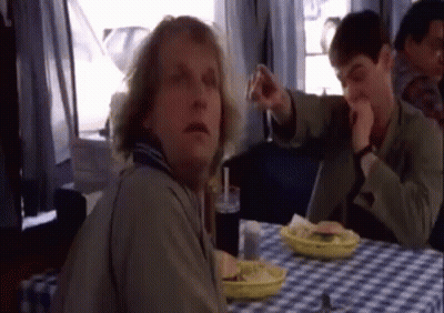 A Man Is Sitting At A Table With A Plate Of Food GIF