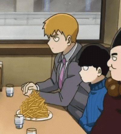 A Man Is Sitting At A Table With A Plate Of French Fries . GIF