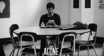 A Man Is Sitting At A Table With A Tray Of Food And A Laptop . GIF