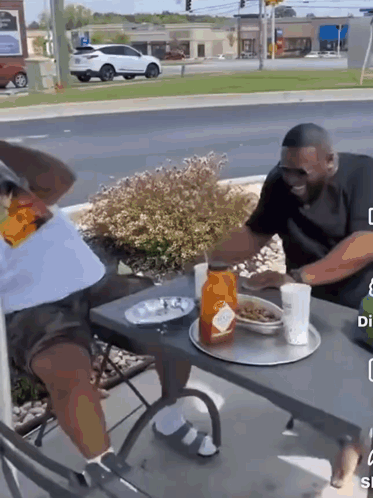 A Man Is Sitting At A Table With A Tray Of Food On It GIF