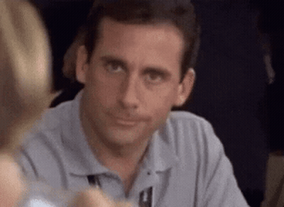 A Man Is Sitting At A Table With A Woman And Smiling . GIF