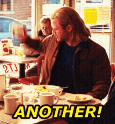A Man Is Sitting At A Table With Another Written On The Table GIF