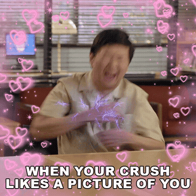 A Man Is Sitting At A Table With Hearts Around Him And The Caption Says When Your Crush Likes A Picture Of You GIF