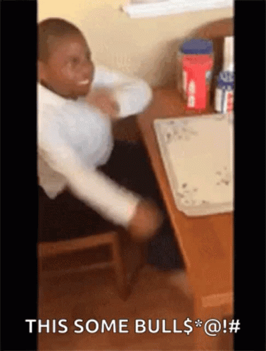 A Man Is Sitting At A Table With His Arms Outstretched And The Words This Some Bull $ * @ ! GIF