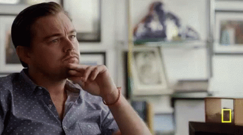 Man Sitting At Table With Hand On Chin GIF