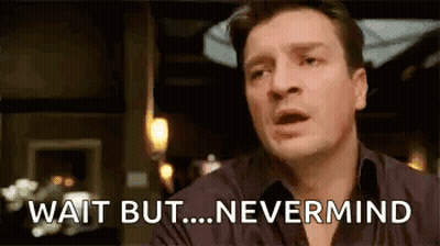 A Man Is Sitting At A Table With His Mouth Open And Says `` Wait But ... Nevermind '' . GIF