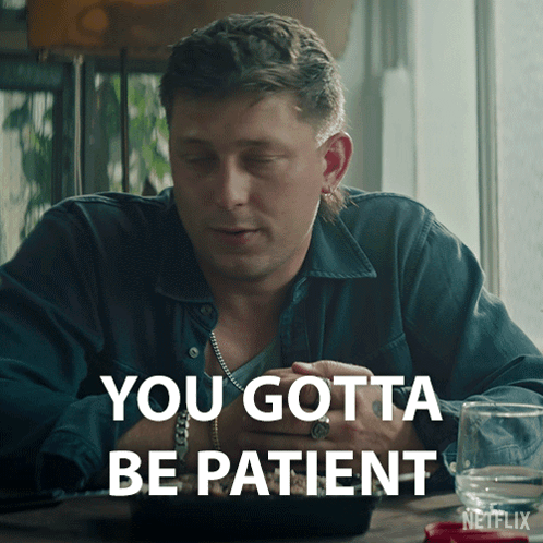 A Man Is Sitting At A Table With The Words You Gotta Be Patient On The Bottom GIF