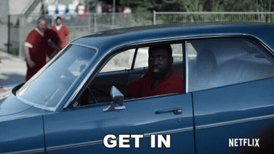 A Man Is Sitting In A Blue Car That Says Get In On The Side GIF