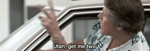 A Man Is Sitting In A Car And Talking To Another Man . GIF