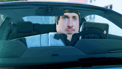 A Man Is Sitting In A Car With A Laptop On His Lap GIF