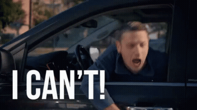A Man Is Sitting In A Car With His Mouth Open And Shouting . GIF
