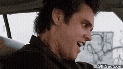 A Man Is Sitting In A Car With His Mouth Open . GIF