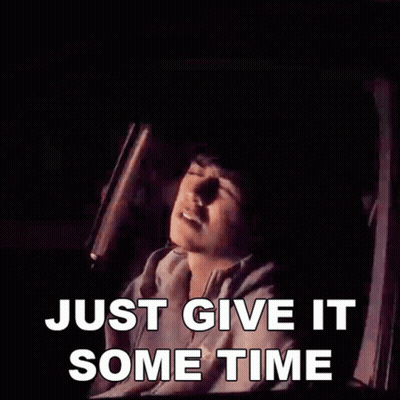 A Man Is Sitting In A Car With The Words Just Give It Some Time Above Him GIF