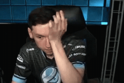 A Man Is Sitting In A Chair And Covering His Face With His Hand . GIF