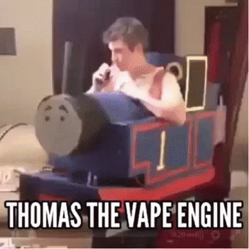 A Man Is Sitting In A Chair Dressed As Thomas The Tank Engine And Smoking A Cigarette . GIF