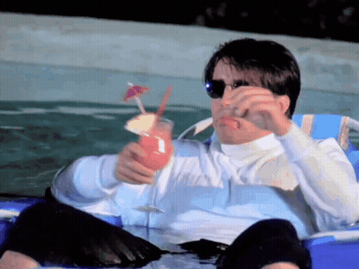 A Man Is Sitting In A Chair Holding A Drink In His Hand GIF