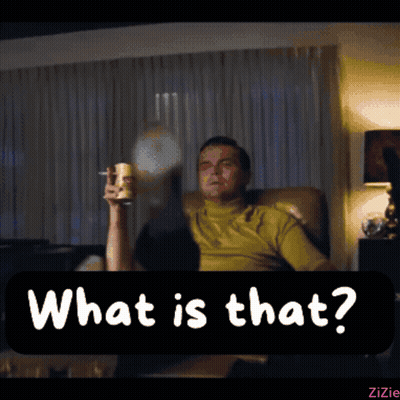 A Man Is Sitting In A Chair Holding A Glass And A Cigarette And The Words What Is That Are Above Him GIF