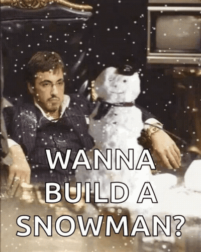 A Man Is Sitting In A Chair Holding A Snowman With The Words " Wanna Build A Snowman " On The Bottom GIF
