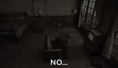 A Man Is Sitting In A Chair In A Dark Room With The Words `` No '' Written On The Screen . GIF