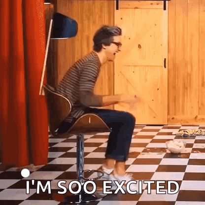A Man Is Sitting In A Chair On A Checkered Floor And Says `` I 'M Soo Excited '' . GIF