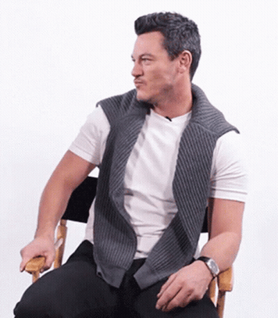 A Man Is Sitting In A Chair Wearing A Watch GIF