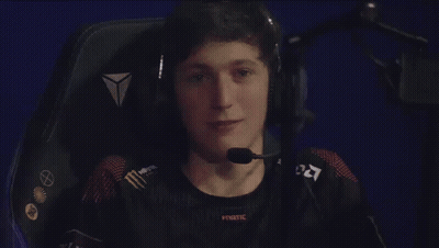 A Man Is Sitting In A Chair Wearing Headphones And A Microphone . GIF