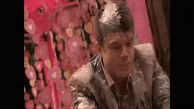 A Man Is Sitting In A Chair With A Lot Of Foam On His Head . GIF
