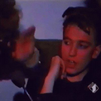 A Man Is Sitting In A Chair With A Tv Icon On His Shirt GIF