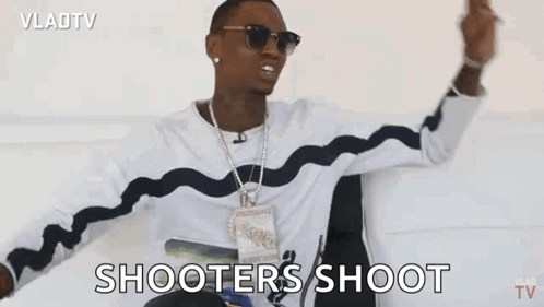 A Man Is Sitting In A Chair With His Arms In The Air And Says Shooters Shoot . GIF