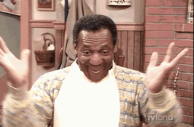 A Man Is Sitting In A Chair With His Arms Outstretched And Smiling . GIF