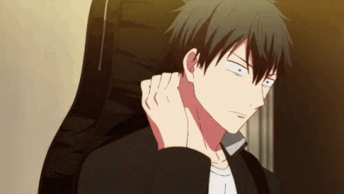 A Man Is Sitting In A Chair With His Hand On His Ear And Looking At The Camera . GIF