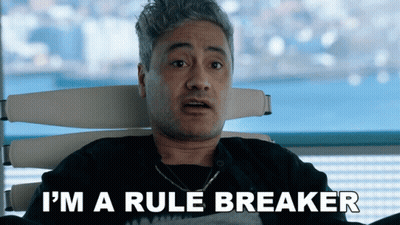 A Man Is Sitting In A Chair With The Words I 'M A Rule Breaker Above Him GIF