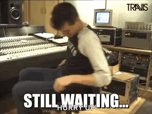 A Man Is Sitting In A Chair With The Words Still Waiting Hurry Up GIF