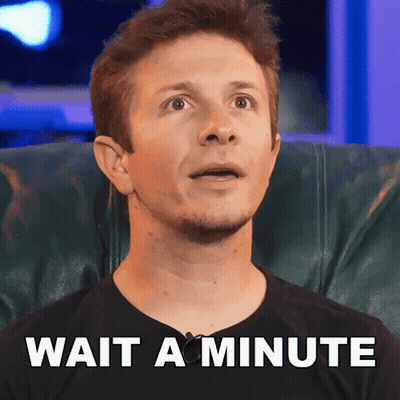 A Man Is Sitting In A Chair With The Words Wait A Minute Written On The Bottom GIF