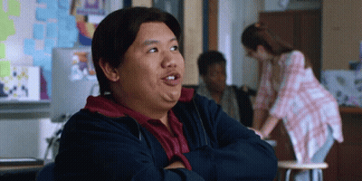 A Man Is Sitting In A Classroom With His Arms Crossed And His Mouth Open GIF