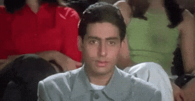 A Man Is Sitting In A Crowd Of People Watching A Movie And Making A Funny Face . GIF