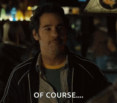 A Man Is Sitting In A Dark Room With His Eyes Closed And Making A Funny Face . GIF
