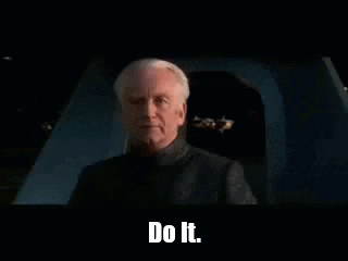 A Man Is Sitting In A Dark Room With The Words `` Do It '' On The Screen . GIF