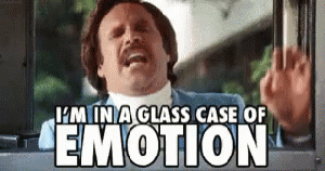 A Man Is Sitting In A Glass Case Of Emotion And Waving . GIF