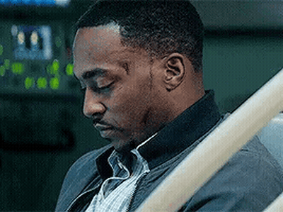 A Man Is Sitting In A Hospital Bed With His Eyes Closed And A Scar On His Face . GIF