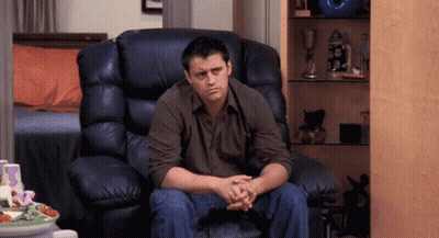 A Man Is Sitting In A Leather Chair With His Hands Folded GIF