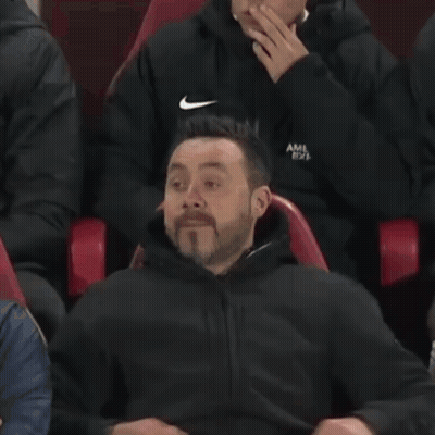 A Man Is Sitting In A Red Chair With His Face Covered . GIF